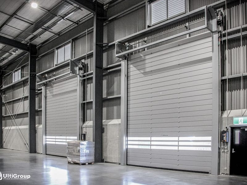 Two Ulti Spiral Doors installed in a large industrial warehouse facility.